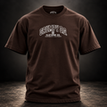 Dark Chocolate Grumpy O.G. Standard Tee with collegiate-style branding across the chest.