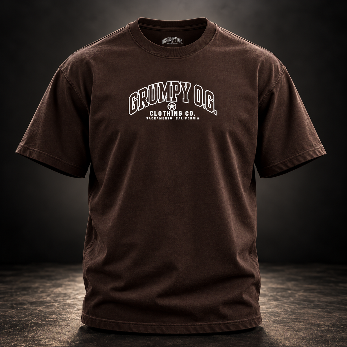 Dark Chocolate Grumpy O.G. Standard Tee with collegiate-style branding across the chest.